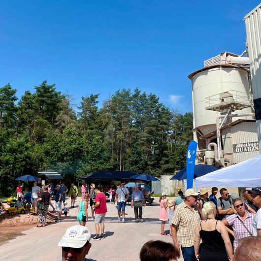 Many people visit the Wellmersdorf quartz sand plant on a sunny day during an open house event.
